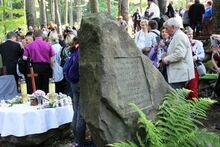 Menschen um einen Gedenkstein